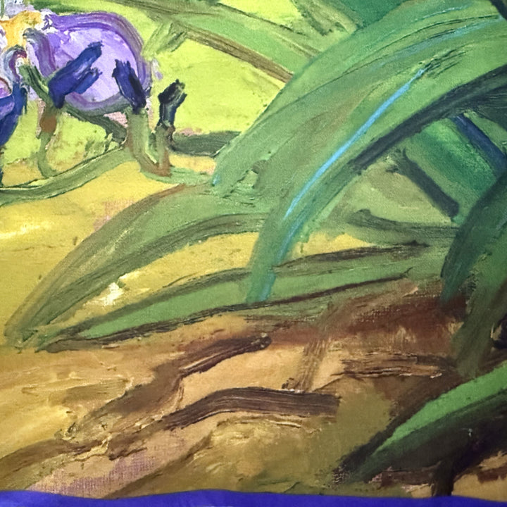 Close-up of purple flowers, green leaves and multicoloured background on the silk fabric.