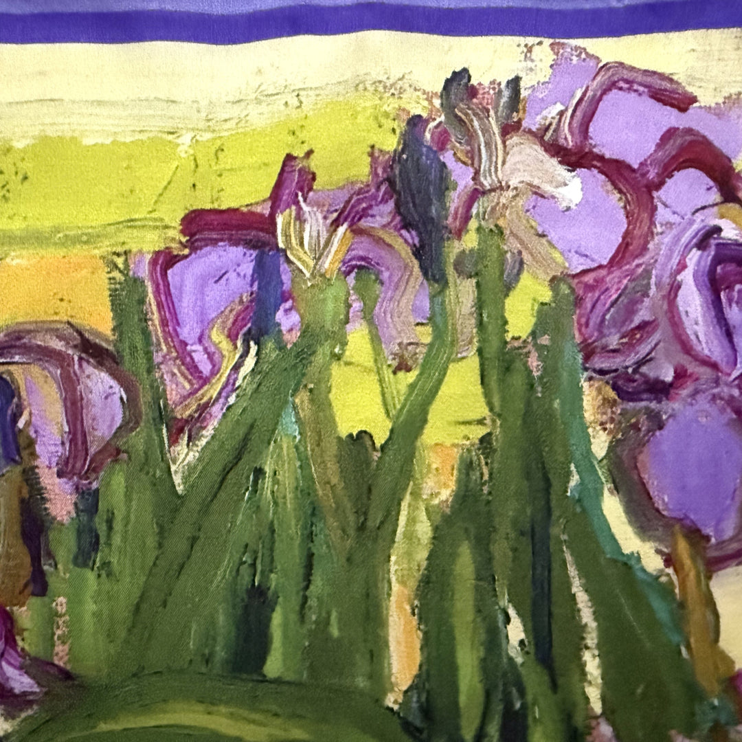 Close-up of purple flowers and green leaves on the silk fabric.