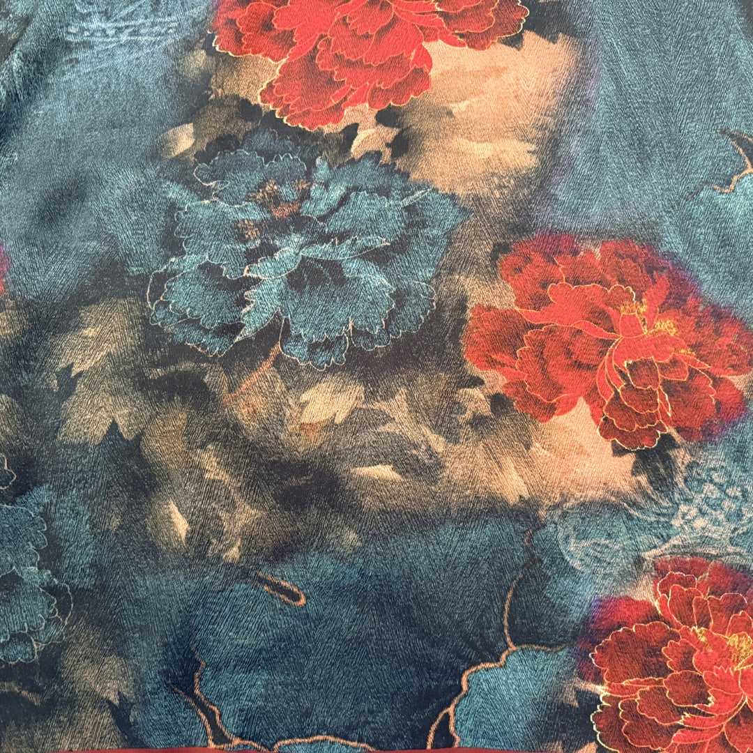 Close-up of large red and blue floral print on silk fabric.