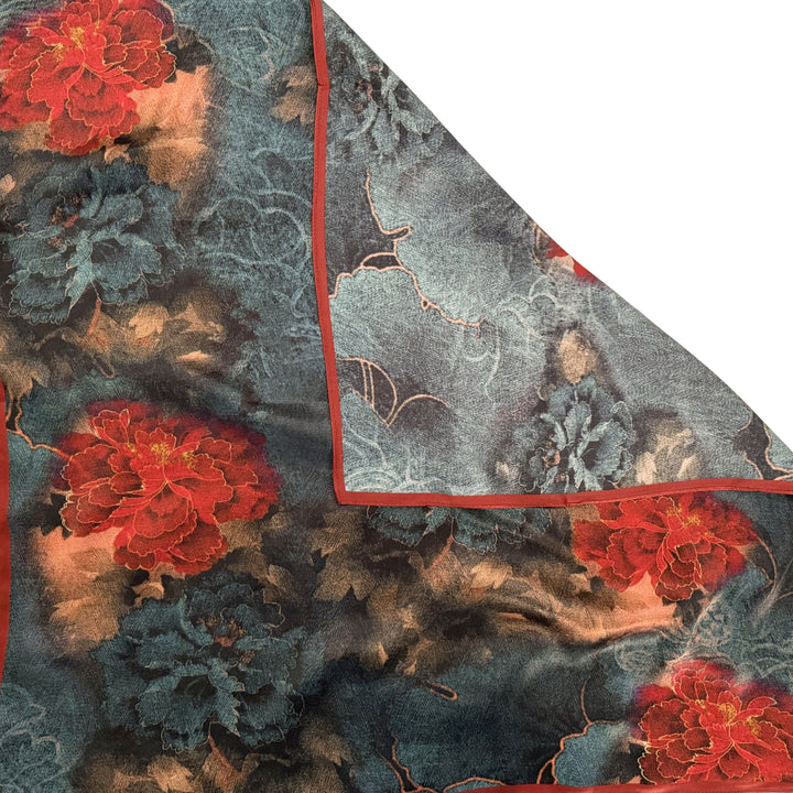 Red and blue floral silk scarf with folded corner showing the reverse side and one-sided print.