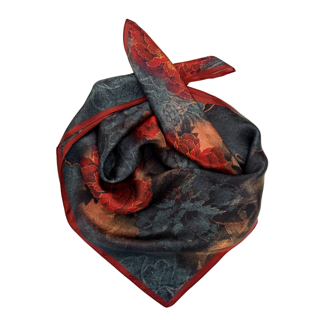 Red and blue floral silk scarf neatly folded highlighting the bold floral design.