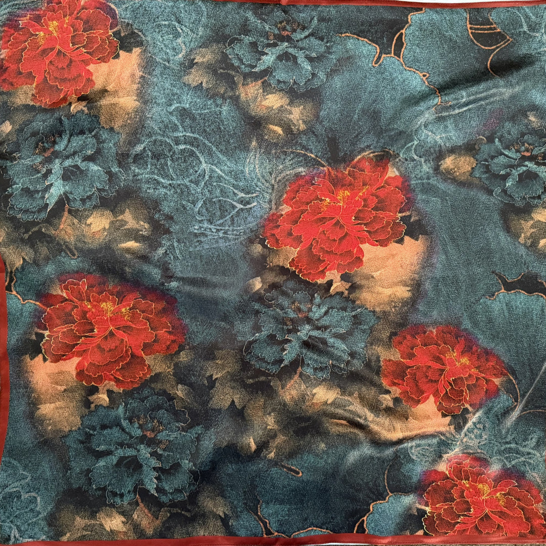 Red and blue floral silk scarf with red border shown in full top view.