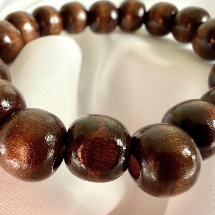 Close-up of a brown wooden bracelet made entirely of round wooden beads.