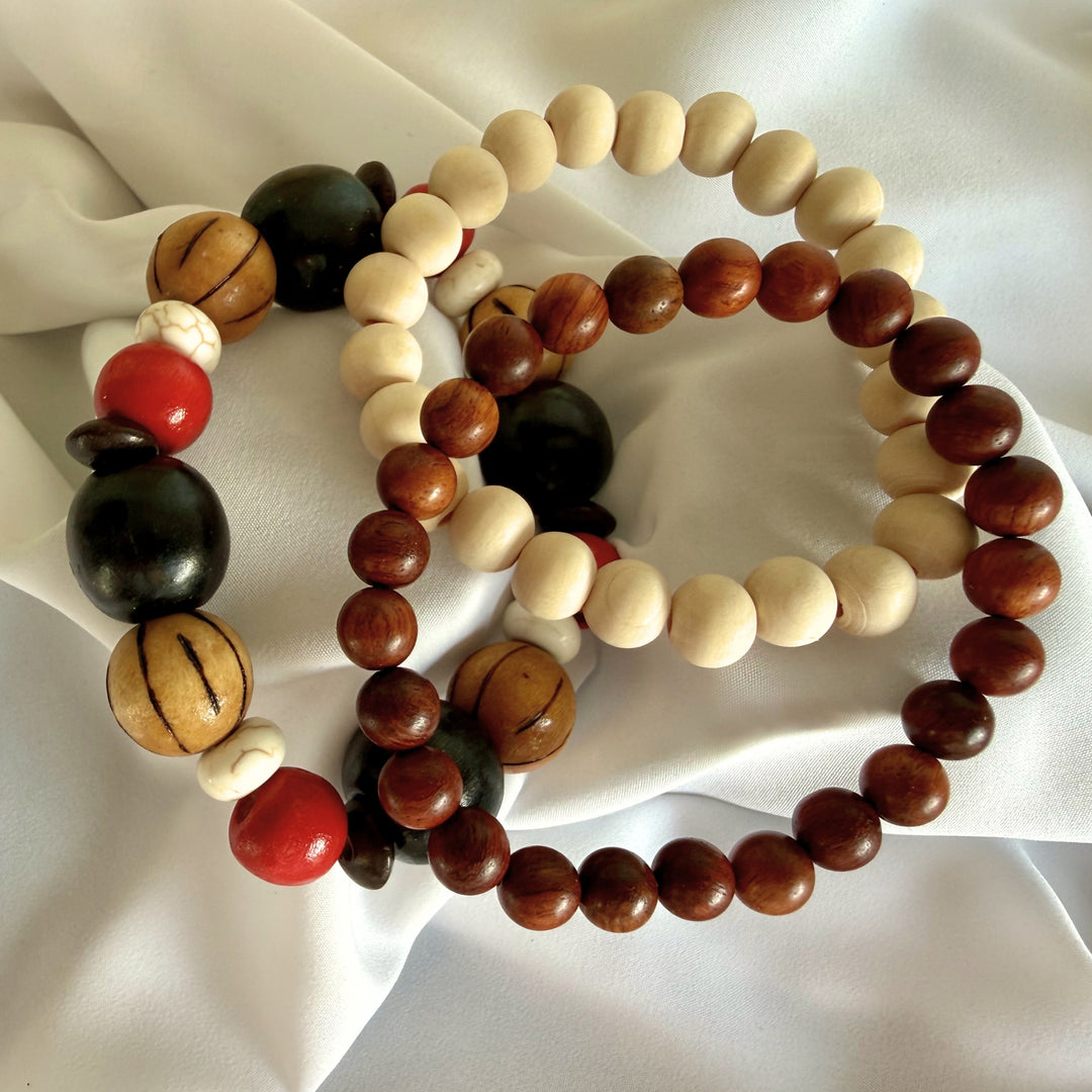 Full view of three handcrafted beaded bracelets featuring wood and howlite beads layered together in earthy tones.