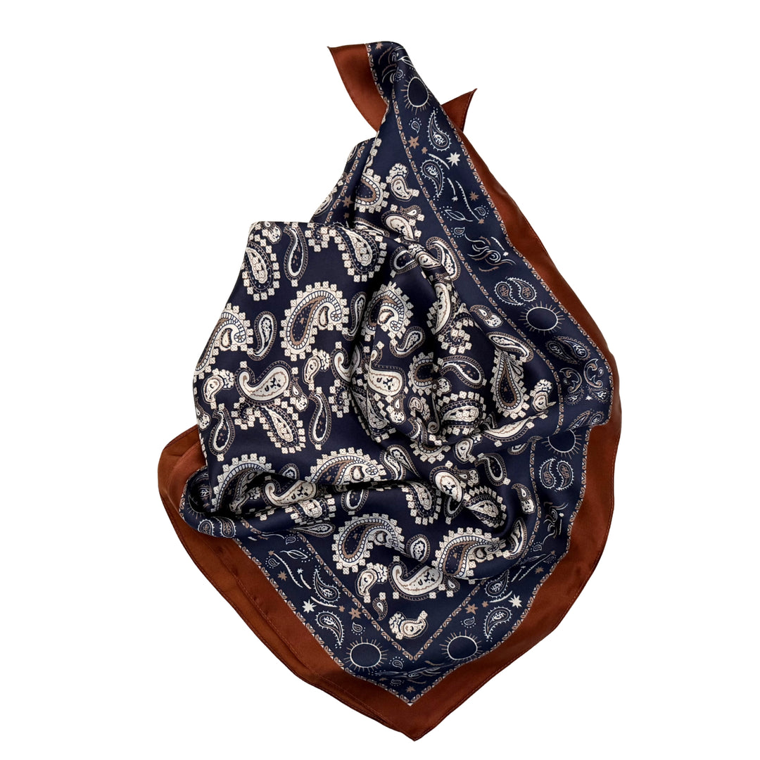 Paisley silk scarf neatly folded showing the detailed paisley design and copper edge.