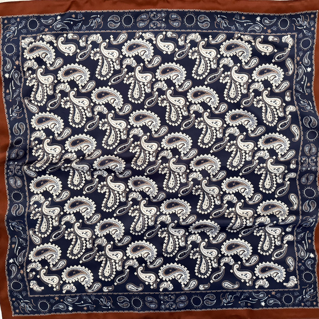 White, beige and navy paisley silk scarf with copper edge shown in full top view.