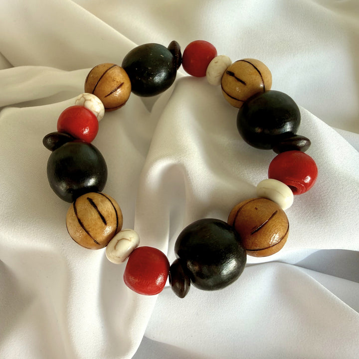Full view of a handcrafted bracelet combining wood and howlite beads in maroon, black, and brown tones.