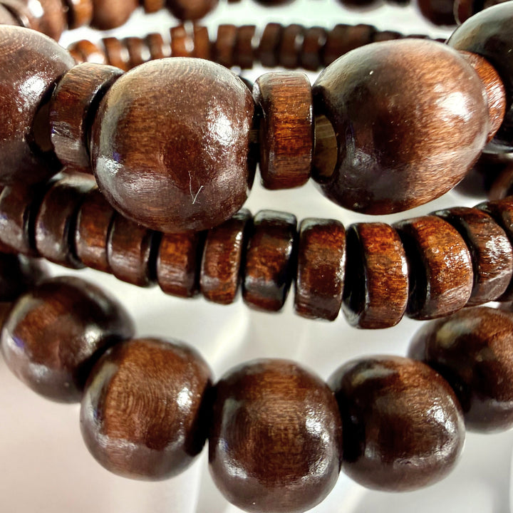 Close-up view of three brown wooden beaded bracelets showing texture and bead variations.